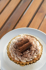 Cupcake white cream and chocolate roll with  chocolate powder in