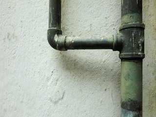 Urban ghetto pipe plumbing against grungy wall texture