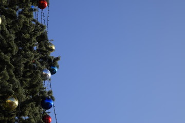Decorations New Year tree. Tinsel and toys, balls and other decorations on the Christmas Christmas tree standing in the open air