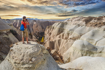 Young woman take photo majestic sunset in Cappadocia