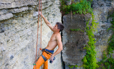 Climber climbs the rock.