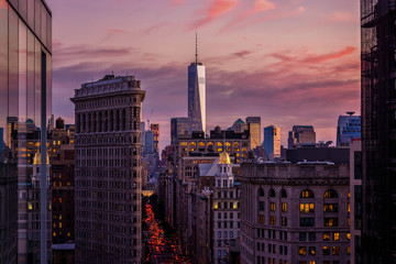 Rooftop view of New York City, Midtown, looking downtown towards Flatiron building and One World Trade Center during sunset.