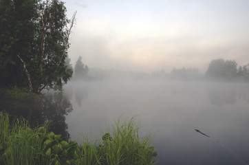 Fototapeta na wymiar Foggy summer landscape with river