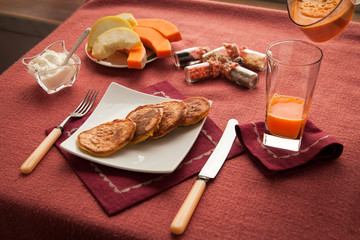 Healthy breakfast with pancakes and pumpkin juice. Full of vitamins fresh pumpkin juice as beverage with fritters.