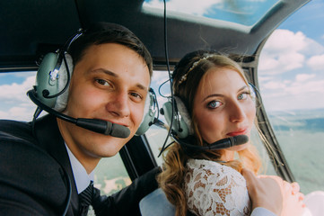 Happy beautiful newlyweds in the helicopter