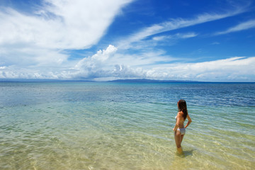 Fototapeta na wymiar Young woman in bikini standing in clear water on Taveuni Island,