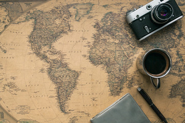 Vintage Camera, Notebook, Pen, Metal Coffee Cup on Retro World Map