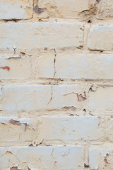 Poorly painted wall of damaged red brick with white paint, textu