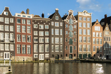Fototapeta na wymiar Houses in in a street by a canal in Amsterdam