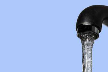 Faucet with running water isolated on blue background