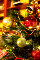 Christmas tree decorated with colored balls is in the apartment.