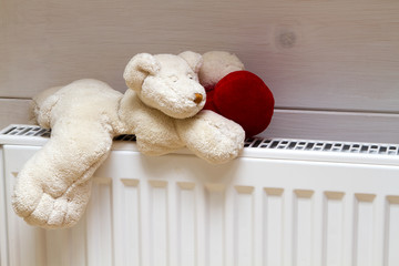 Heating radiator with teddy bear indoors