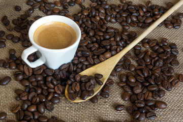 Cup and grain of coffee over textile background