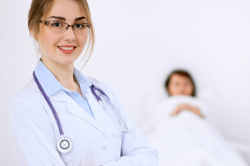 Fototapeta premium Female doctor smiling on the background with patient and his doctor