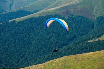 Paragliders fly over the mountains in the competition. Carpathian mountains, Ukraine.