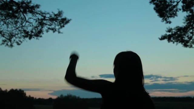 Young woman dancing in the forest after sunset. Freedom and happiness concept.