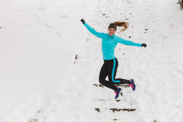 Fototapeta na wymiar Young girl jumping on the snow.