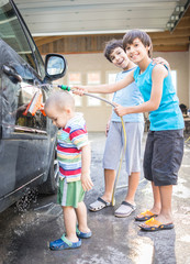 Young father and little sons washing ca