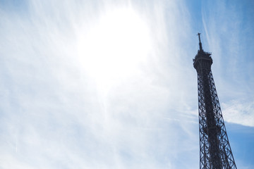 Eiffel Tower top section in Paris, with beautiful wispy clouds i