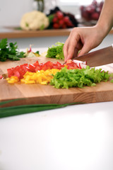 Close up of  woman's hands cooking in the kitchen. Housewife slicing ​​fresh salad. Vegetarian and healthily cooking concept