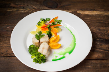 Boiled seabass with steamed vegetables - totally healthy meal. Top view. Close-up