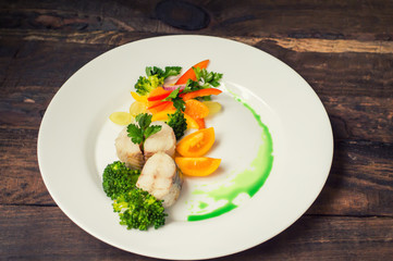 Boiled seabass with steamed vegetables - totally healthy meal. Top view. Close-up