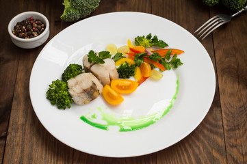 Boiled seabass with steamed vegetables - totally healthy meal. Top view. Close-up