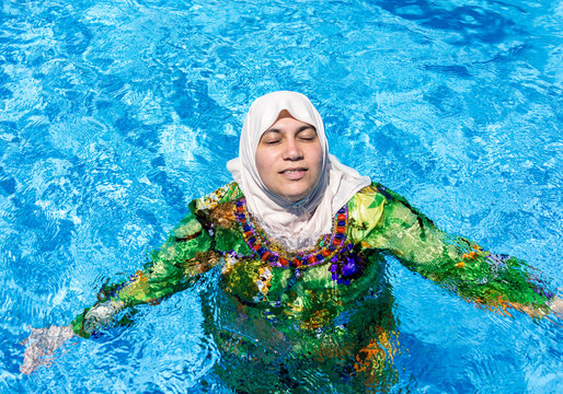 Muslim Arabic woman with burkini in pool