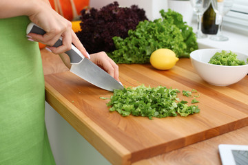 Closeup of woman hands cooking vegetables salad in kitchen. Healthy meal and vegetarian concept.