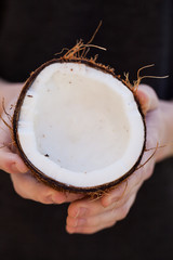 Opening up and carving a raw coconut in hands macro shot