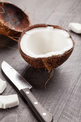 Opening up and carving a raw coconut on a wooden background