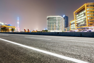 Fototapeta na wymiar Asphalt road and modern cityscape at night in Shanghai