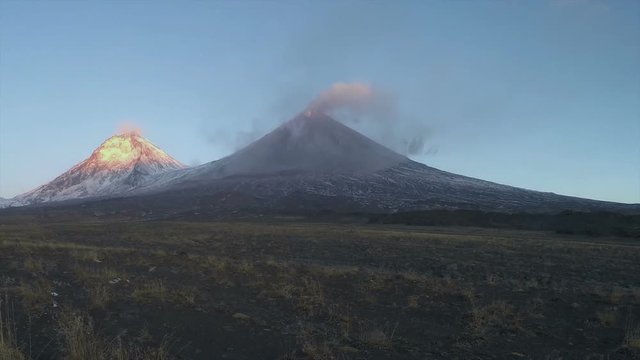 Volcanic landscape of Kamchatka (time lapse): view of eruption Klyuchevskoy Volcano at sunrise; plume of gas, steam, ash from active crater. Kamchatka Peninsula, Klyuchevskaya Group of Volcanoes.