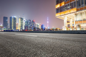 Fototapeta premium Asphalt road and modern cityscape at night in Shanghai