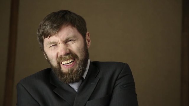 bearded business executive man wears a jacket, yawning and shaking from a cold on a next day after a party