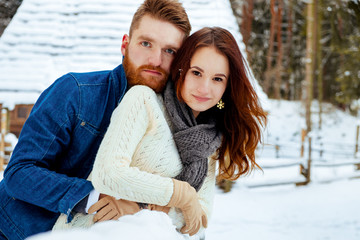 loving couple walking in winter park. The snowfall