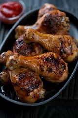 Closeup of barbecued chicken legs served in a frying pan
