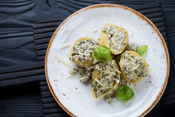 Baked conchiglioni with spinach and cottage cheese on a plate
