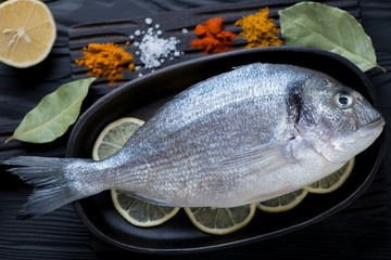Close-up of fresh uncooked dorado fish in a frying pan