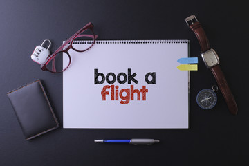 Travel concept with notebook written book a flight with passport