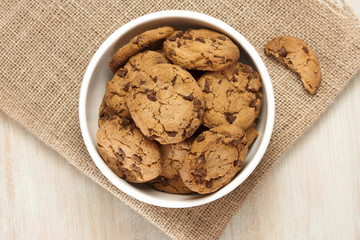 Bowl of chocolate chips cookies on burlap with copyspace