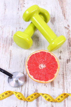 Fresh grapefruit, centimeter, stethoscope and dumbbells, healthy lifestyles