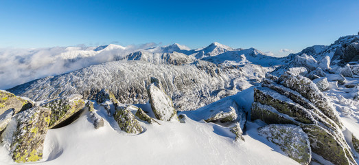 Bright winter scenery in the mountains, with frost and rocks covered with fresh snow