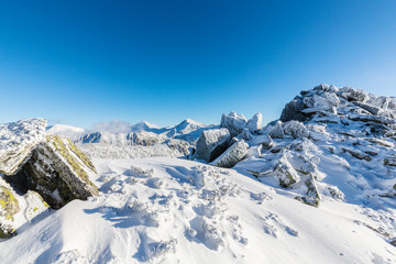 Bright winter scenery in the mountains, with frost and rocks covered with fresh snow