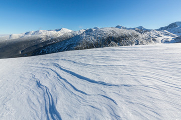 Bright winter scenery in the mountains, with frost and rocks covered with fresh snow