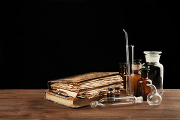 Vintage medicine bottles and books on wooden table