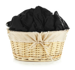 Clothes in wicker basket on white background