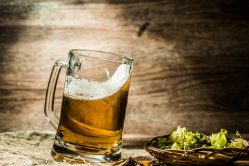 Beer in big tankard closeup standing on wooden table