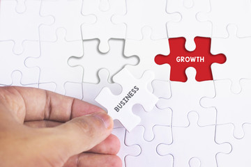 Fototapeta premium Business Concept - Female hand and missing puzzle with BUSINESS GROWTH WORD