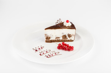 Sour cream cake with curd cream on a plate with red currant on a white background
